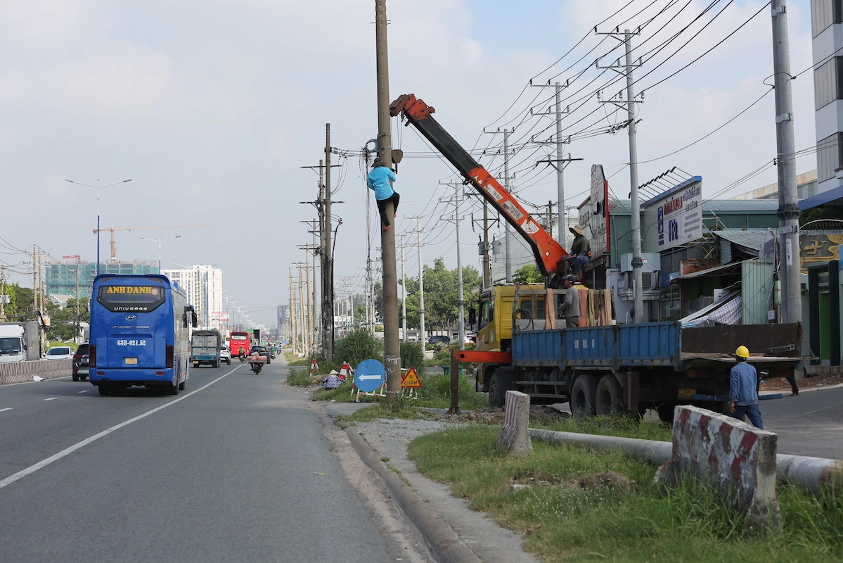 Công nhân di dời trụ điện trên Quốc lộ 13 phục vụ dự án Nâng cấp mở rộng đoạn qua TP Thuận An - Ảnh sưu tầm